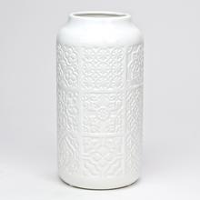 Biela keramická váza s výrezom a kvetinovým vzorom.