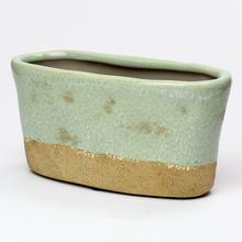 Zelený keramický obal hrantík s hladkým povrchom.