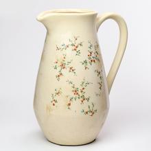 Keramický džbán s uchom a kvetinovým vzorom.