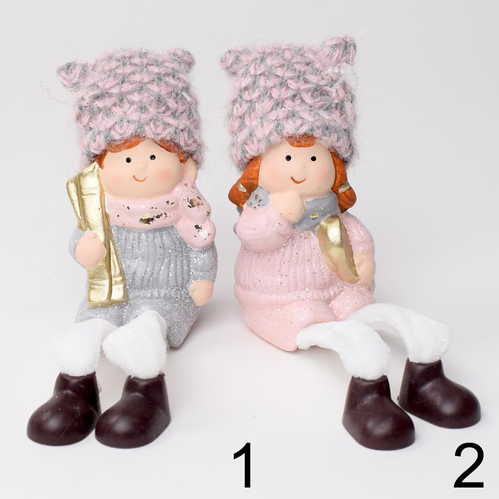 Dve keramické postavičky detí v zimných oblekoch s čiapkami.