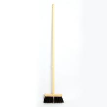 Klasická metla s dlhým dreveným držadlom a čiernymi štetinami.