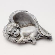 Sivý anjel v krídlach, smútočný dekoratívny predmet.