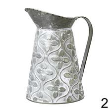 Malý kovový džbán so zeleným ornamentom.