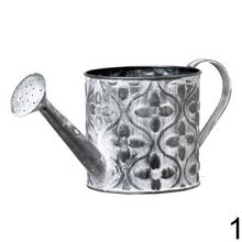 Malá kovová váza s ornamentom v zelenej farbe.