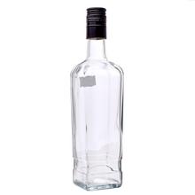 Priehľadná sklenená fľaša s čiernym uzáverom.