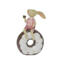 Ružový zajačik sediaci na donute.