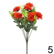 Umelá kytica chryzantémy so zelenými listami.