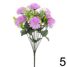 Umelá kytica chryzantémy so zelenými listami.