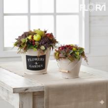 Jesenné aranžmá s ovocím a kvetmi v bielej nádobe.