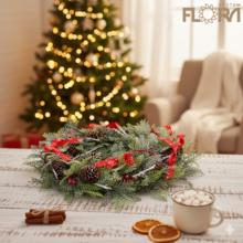 Vianočný veniec s červenými stuhami a šiškami.