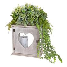 Smútočná väzba s dekoratívnymi rastlinami a sviečkou.