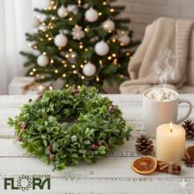Vianočný veniec so zelenými listami a bobuľami.