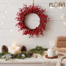 Vianočný veniec s červenými bobuľami a prútím.