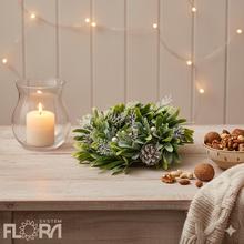 Vianočný veniec so šiškami a zelenými listami.