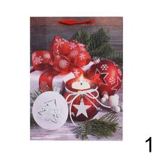 Vianočná darčeková taška s červenými kvetmi a sviečkou.