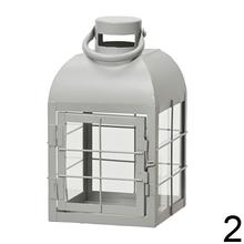 Kovový lampáš v troch farbách: čierny, šedý a biely.