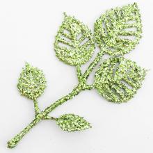 Umelé kvety vianočné so zlatozelenými brokátovými listami.