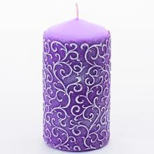 Fialová vianočná sviečka s ornamentom.