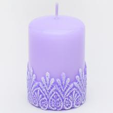 Fialová vianočná sviečka s ornamentom.