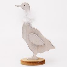 Drevená biela huska s pierkom.