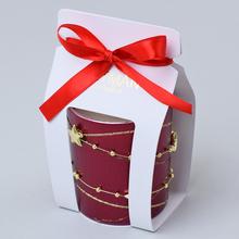 Voňavá sviečka v bordovom skle s červenou stuhou.