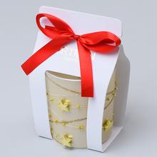 Voňavá sviečka v sklenenom obale s červenou stuhou.