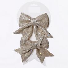 Sada dvoch zlatých mašlí s trblietkami.