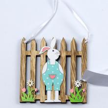 Závesná dekorácia zajaca pri plote z dreva.