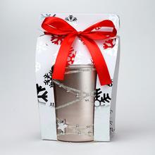 Voňavá sviečka v sklenenom obale s ružovým zlatom a červenou stuhou.