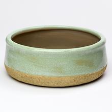 Zelený keramický obal v tvare kruhu.