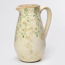 Keramický džbán s uchom a zeleným vzorom.