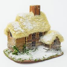 Domček z prírodných materiálov s detailmi snehu.