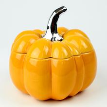 Oranžová porcelánová dóza v tvare tekvice.