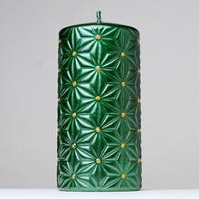 Zelená vianočná sviečka s ornamentom.