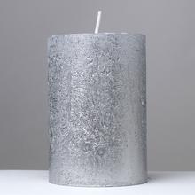 Strieborná sviečka s glitrami, valcového tvaru.