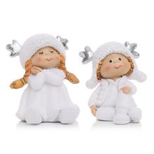 Dve deti sediace s čiapkami a parožím, biele keramické dekorácie.