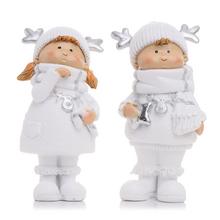 Dve deti v bielych zimných oblekoch s darčekmi.