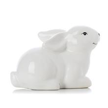 Biely porcelánový zajačik ležiaci na boku.