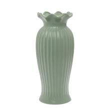 Zelená keramická váza s vlnitým okrajom.