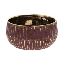 Okrúhly obal burgundskej farby so zlatým okrajom.