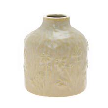 Malá krémová váza s vzorom trávy.