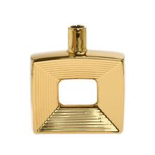 Zlatá keramická váza s geometrickým tvarom.