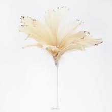 Kvetinový aranžérsky materiál s perím v krémovej farbe.