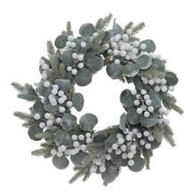 Vianočný veniec s čečinou, eukalyptom a bielymi bobuľami, zasnežený.