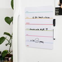 Plánovač na magnet pripevnený na chladničku s farebnými sekciami na dni v týždni.